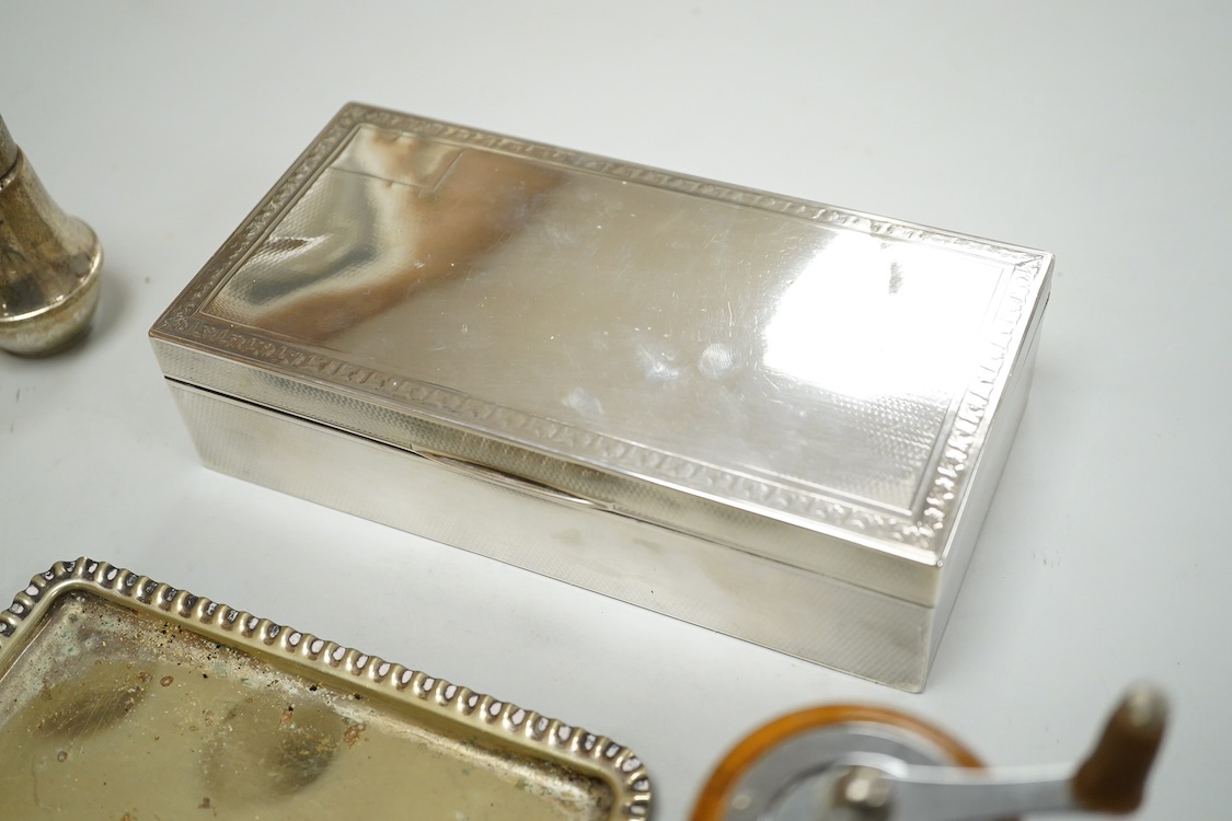 A George V engine turned silver mounted rectangular cigarette box, Birmingham, 1923, 17.7cm, a sterling mounted pepper grinder, four weighted sterling condiments and a small plated tray.